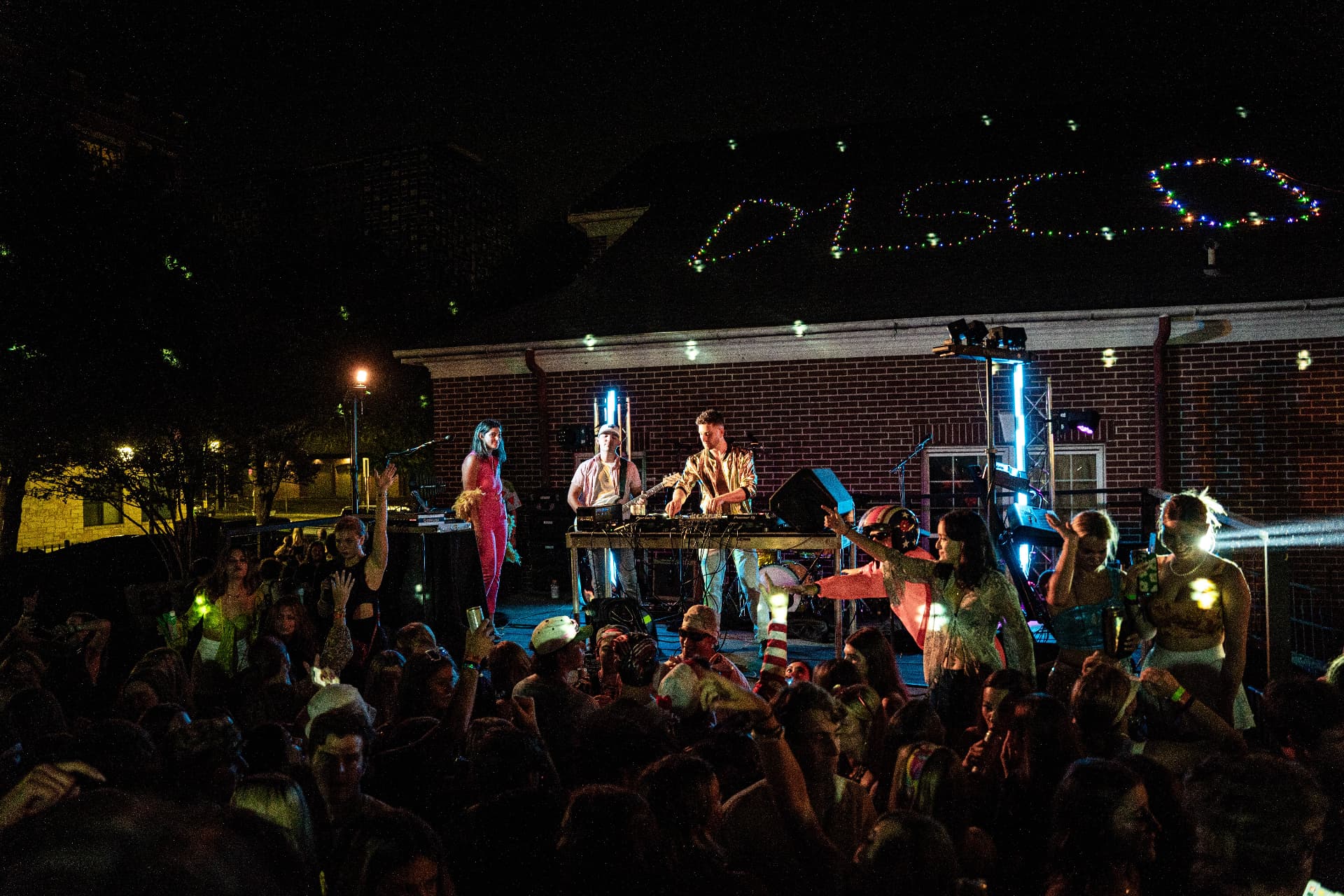 Mixmode performing on an outdoor campus stage in front of a packed student crowd