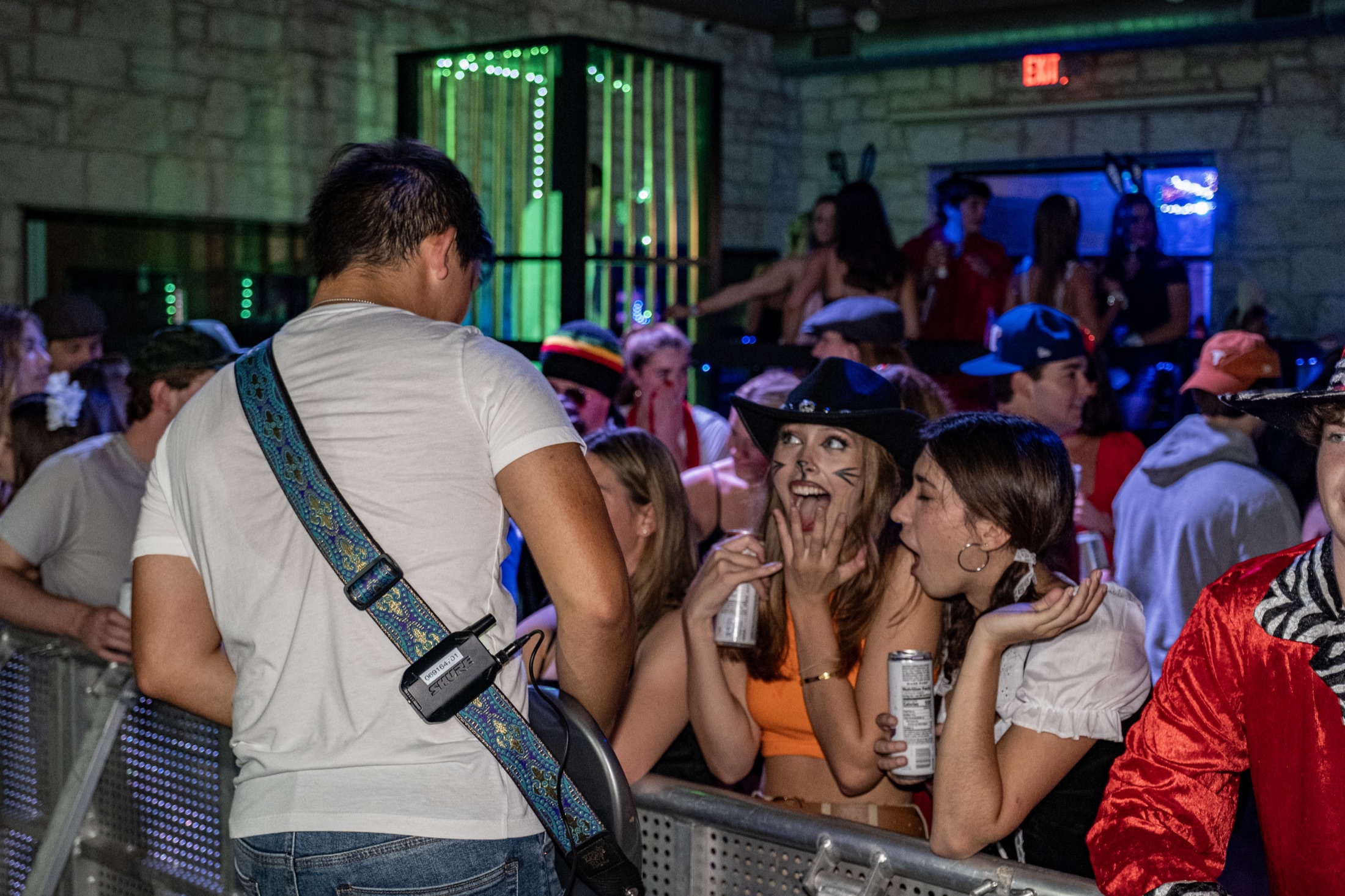 Students in costume singing along at the barricade while Kristian Cruz plays guitar to the front row