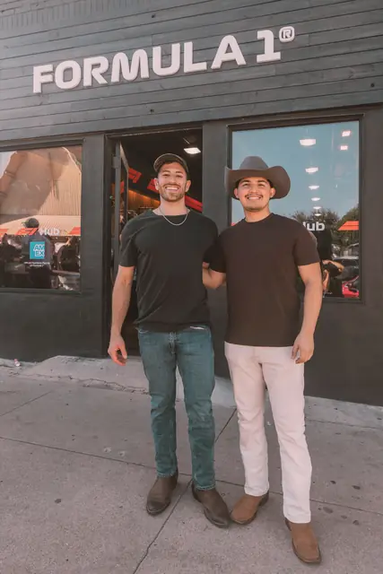 Jordan Miller and Kristian Cruz of MIXMODE under the Formula 1 sign at the Lucchese pop-up