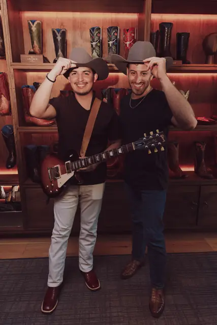 Jordan Miller and Kristian Cruz tipping their hats inside Lucchese