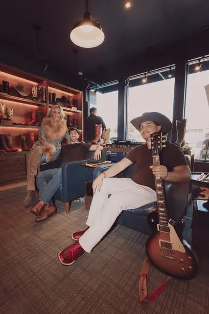 Kristian Cruz and Jordan Miller in the Lucchese lounge with a guitar