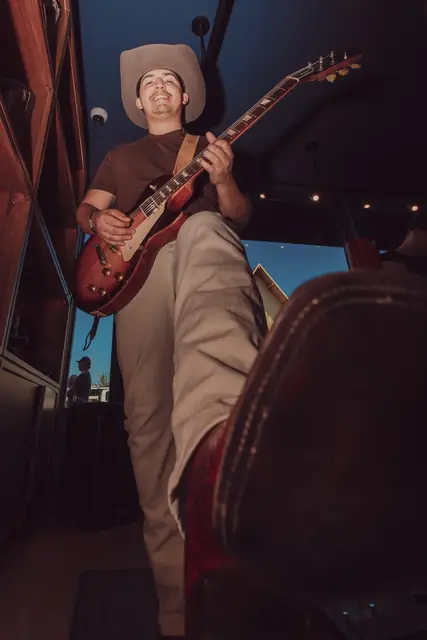 Kristian Cruz playing live guitar at the Lucchese F1 Weekend pop-up